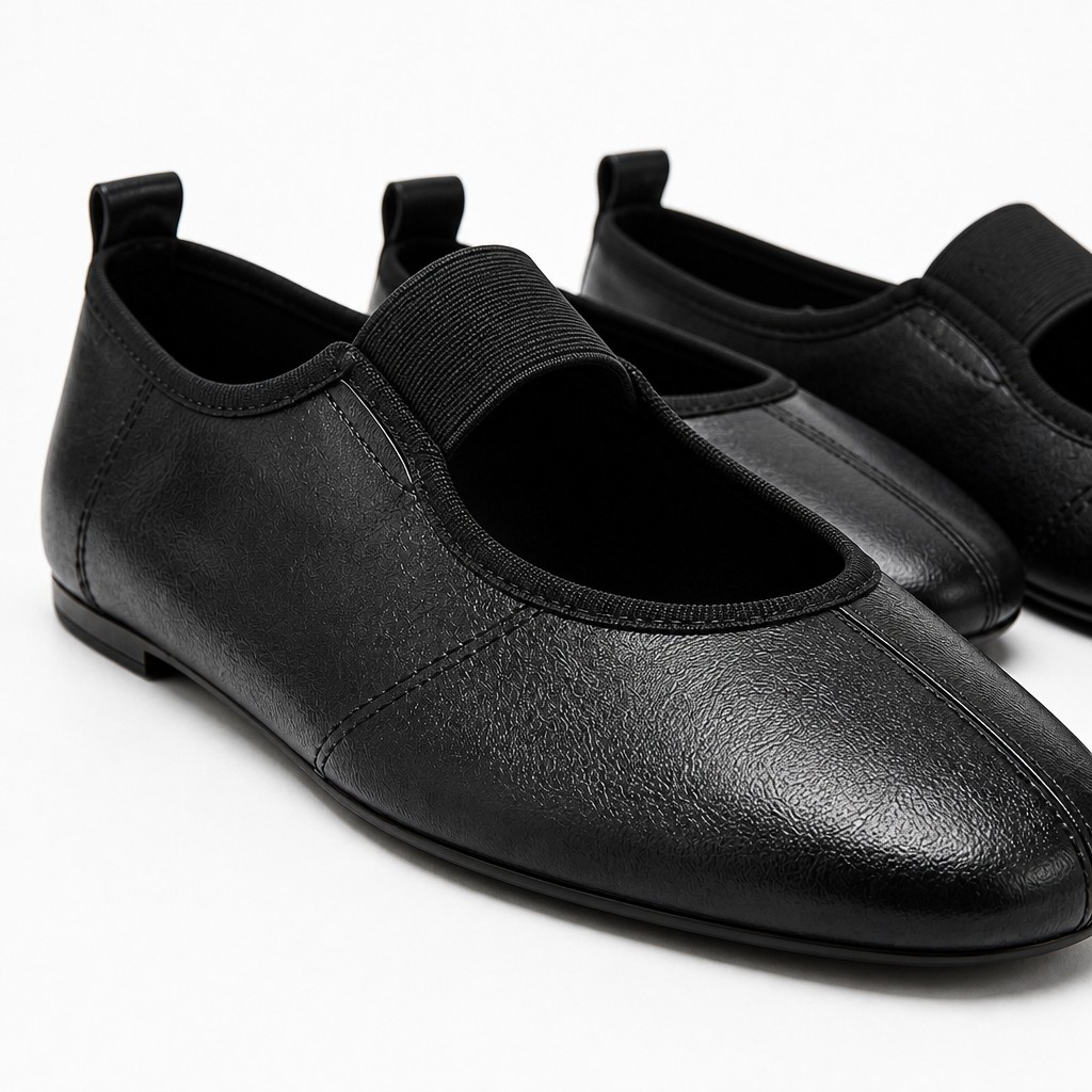 Close-up detail of black flats showing textured upper opening and elastic strap