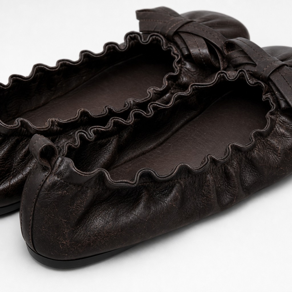Detail view of ruffled opening and material texture on black flat shoe