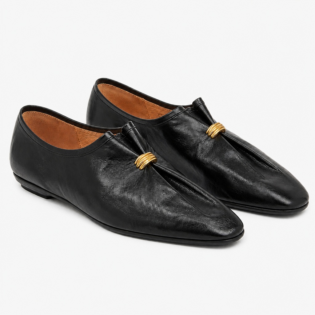 Musta retro laskostettu loafer-pari valkoisella pohjalla