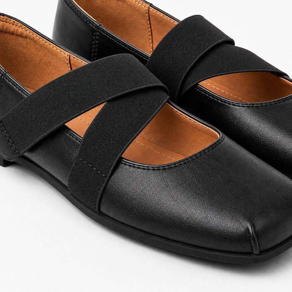Primo piano di scarpe Mary Jane nere che mostrano la trama della pelle, le cuciture e i cinturini incrociati.
