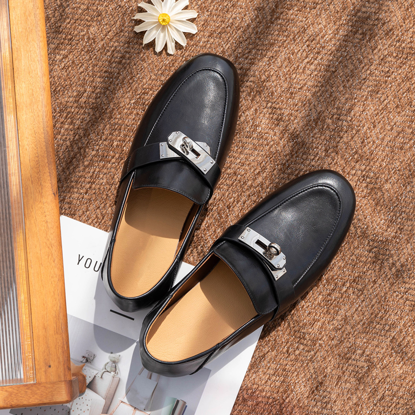 Une paire de mocassins noirs dans un cadre lifestyle vu de dessus.