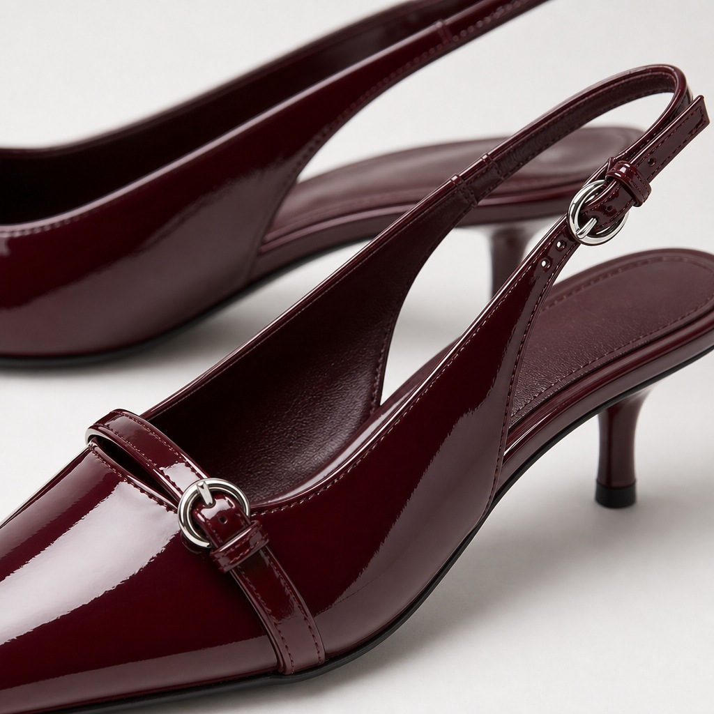 Close do salto tipo slingback cor de vinho mostrando a parte superior em PU brilhante e a tira com fivela