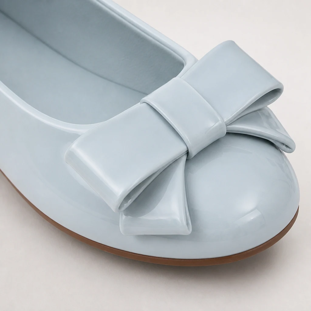 Detailopname van de glanzende strik en het bovenste detail van de ballerina's.
