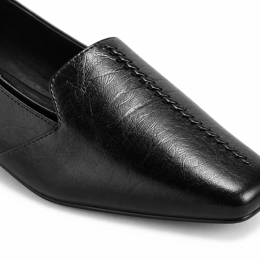 Lähikuva yksityiskohta kiiltävää nahkaa näyttävää loafer-materiaalia ja ompeleita