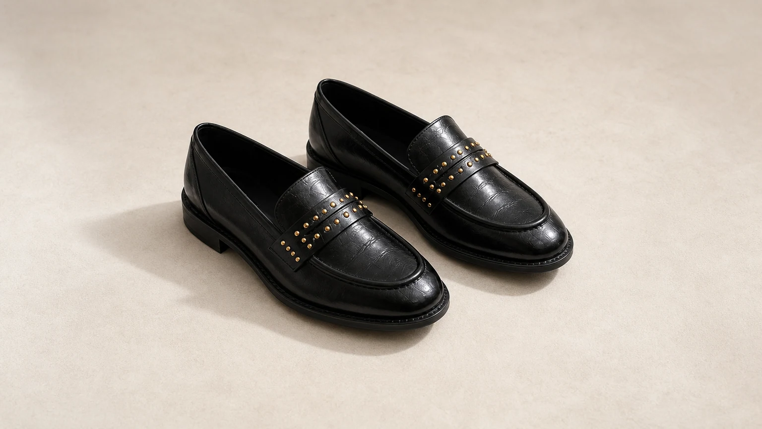 Bold gloss black loafers styled in a horizontal hero scene